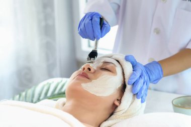 Genç Asyalı kadınlar yüz bakımı, yüz maskeleri ve güzellik salonundaki güzellik uzmanları tarafından yumuşak yumuşak ipeksi cilt için spa güzellik tedavisi görüyorlar. Güzellik cilt konsepti