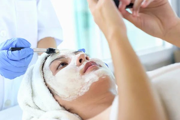 由美容师在温泉沙龙为年轻的亚洲女性提供面部护理 面部面具和温泉美容治疗 治疗柔滑柔滑柔滑的肌肤 美容美发概念 — 图库照片