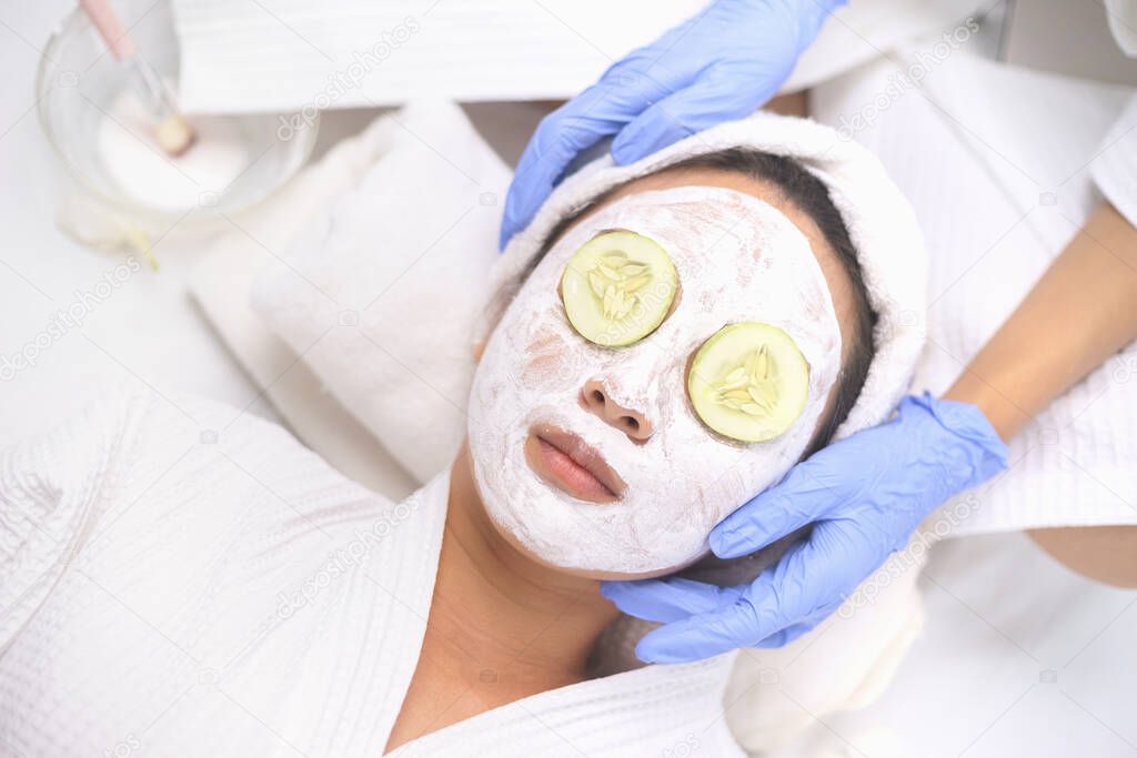 Young Asian Women getting facial care, Facial masks, and spa beauty treatment for soft smooth silky skin. Helps with homemade apply face mask with cucumber slices eyes mask for Tired Eyes.