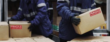 Soğuk hava deposunun yükleme alanından kırılgan kutular alınıyor. Dondurma odasındaki depoyu nakletmeye hazırlanın. Depo Sistemi Destek Lojistik Şirketi Banner boyutunda..