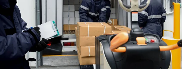Soğuk hava deposunun yükleme alanından paket kutuları alınıyor. Dondurma odasına nakledilmeye hazır olun. Lojistik İş Konsepti Depolama Servisi Sancak boyutunda.