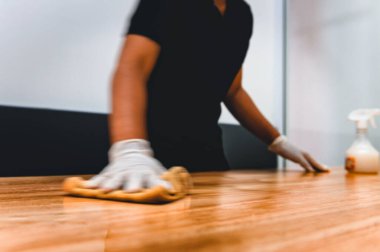 Garson kadının eli dezenfektan spreyli masayı temizliyor ve kapalı restoranda dezenfekte etmek için mikrofiber bez kullanıyor. Hareket filtresi efekti ekle. Coronavirus önleme kavramı.