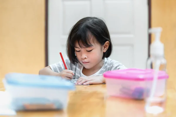 亚洲小女孩坐着练习他们的技巧 把注意力集中在桌上的彩纸上 学前儿童在家学习写作和阅读 艺术教育和创造力 儿童活动 — 图库照片