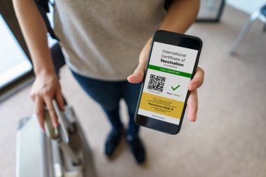 Havaalanında dokunulmazlık pasaportu ve covid-19 için aşı kaydı olan uluslararası bir aşı belgesini göstermek için akıllı telefondan turist başvuruları, hastalık dokunulmazlığı pasaportu.