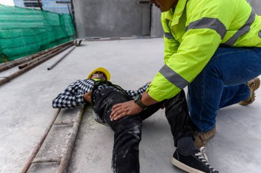 İnşaat işçisinin iş yerinde bir kaza. İnşaat kazasında bina iskelesi çöktü, ilk yardım ekibi acil müdahale için içeri girdi ve çalışan kazasına yardım etti. İş konseptinde güvenlik.