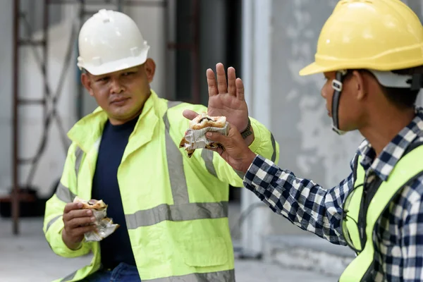 労働者の概念のコロナウイルスや昼食の流行を防止し 社会的距離のために一緒に食べていない休憩時間に座っている間 均一なアジアのビルダーの労働者が食べている — ストック写真