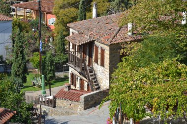 Yunanistan 'ın Nikiti kentindeki geleneksel bir taş ev. Büyüleyici mimari, ahşap balkon ve bereketli yeşillik bu tarihi köyün gerçek güzelliğini ve huzurlu atmosferini yansıtıyor..