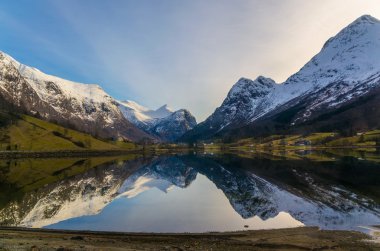 Beatiful norwegian landscape reflecting in fjord without waves clipart