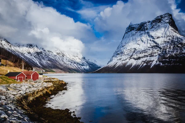 Schönes rotes Ferienhaus am Ufer des tiefblauen norwegischen Fjords — Stockfoto