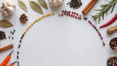 Beyaz ahşap arka planda farklı baharatlardan yapılmış çerçeve, üst görünüm