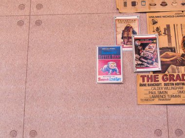 Çeşitli klasik film posterleri ve kahve menüsü olan bir mantar panonun yakın çekimi. Retro estetik, pop kültürü, nostalji..