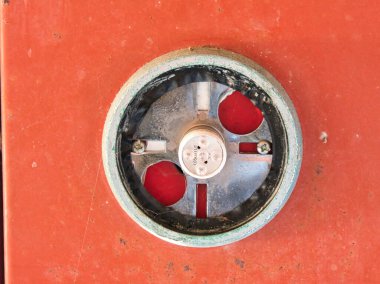 Paslı kırmızı desenli metal bir yüzeye monte edilmiş LED ampuller ve gümüş metal kaplamalı kırık yuvarlak bir araca yakın çekim.