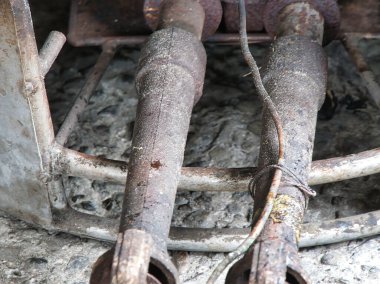 Ağır paslanmış bir çift endüstriyel metal boru yıpranmış beton bir yüzeye dayanır. Çürümüş kentsel atmosfer ve terk edilmiş bir ortamda geçen zamanın altını çizer..
