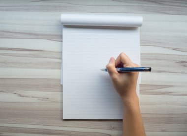 El yazma üstünde tahta arka plan ile defter