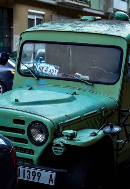 Ön camda hala kullanılmakta olan eski bir yeşil askeri aracın fotoğrafı. 05.02.2026 'da Sırbistan' ın Belgrad kentinde çekilen Rus ve ABD amblemleri var.