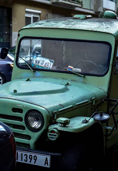 Ön camda hala kullanılmakta olan eski bir yeşil askeri aracın fotoğrafı. 05.02.2026 'da Sırbistan' ın Belgrad kentinde çekilen Rus ve ABD amblemleri var.