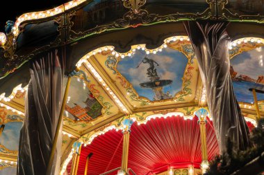 Gdansk, Polonya - 25 Kasım 2024 Vintage atlıkarınca gece boyunca altın ışıklarıyla aydınlatılmış, ayrıntılı atlar ve dekorasyonlar sergilenmektedir. Nostaljik cazibe ve neşeli atmosferle şenlikli bir gezinti..