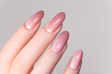 Manikür, minimal tırnak tasarımı, parlak badem şekilli pastel pembe tırnaklar, temiz zarafet, kaplıca güzellik konsepti ve modaya uygun kadınlık..