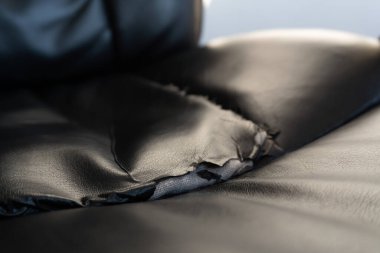 Kırık deri kanepe ya da araba koltuğu dokusu, yırtılmış iç dikişler. Tamir ve yenileme konseptiyle döşemelerde sıkıntı..