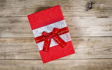 Eski ahşap bir arka planı olan kırmızı hediye kutusu. Yukarıdan görüntüle