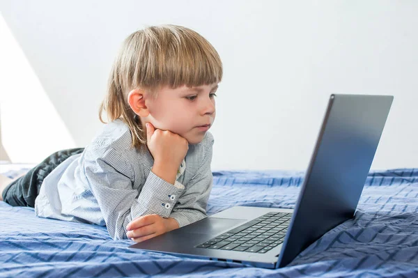 Der Kleine Junge Liegt Bett Und Blickt Auf Einen Laptop — Stockfoto