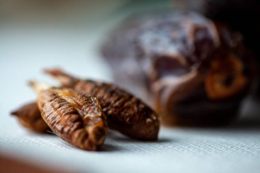 Yemekten sonra bırakılan bir tarih tohumunun tefekküre dayalı makro görüntüsü, Ramazan iftarı anındaki tamamlanma, basitlik ve yansımayı sembolize eder..