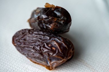Yemekten sonra bırakılan bir tarih tohumunun tefekküre dayalı makro görüntüsü, Ramazan iftarı anındaki tamamlanma, basitlik ve yansımayı sembolize eder..