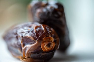 Yemekten sonra bırakılan bir tarih tohumunun tefekküre dayalı makro görüntüsü, Ramazan iftarı anındaki tamamlanma, basitlik ve yansımayı sembolize eder..