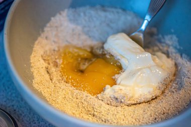 Yumurta, yoğurt ve yulaf ununun karıştırıldığı basit bir pişirme anı ev yapımı hazırlık ve sağlıklı malzemeleri vurguluyor..