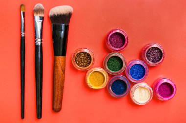 Kırmızı zemin üzerine çeşitli makyaj ürünleri