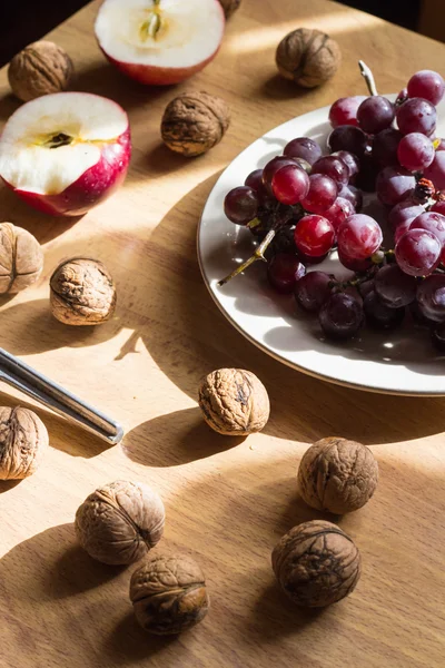 Elma, fındık ve ahşap masa üzüm