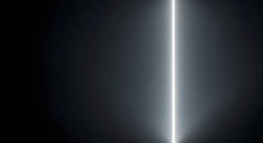 Aşağıdan parlak, dikey bir ışık hüzmesi yayılıyor, koyu renkli bir arka planda parıldıyor. Soyut ve gelecekçi.