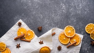 Kurutulmuş portakal dilimleri, tarçın çubukları, gri masadaki beyaz havludaki yıldız anason, fotokopi alanı, üst manzara, şenlikli yeni yıl mutfak arka planı, Noel menüsü