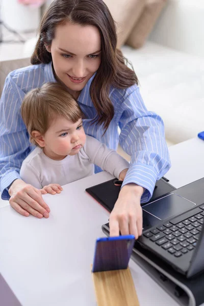 Lächelnde Brünette Frau Mit Kind Sitzt Laptop Nimmt Videoanrufe Entgegen — Stockfoto