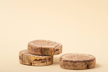 Bej arka planda üç yuvarlak ahşap platform, geometrik podyum, kaide, taklit, güzellik ürünlerinin sunumu için eko sahnesi, maket, ahşap tahta.