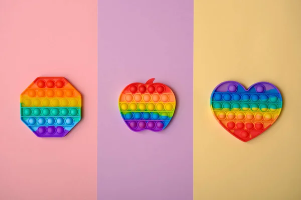 Trendige Drei Regenbogen Pop Fidget Spielzeug Auf Buntem Hintergrund Antistress Stockbild