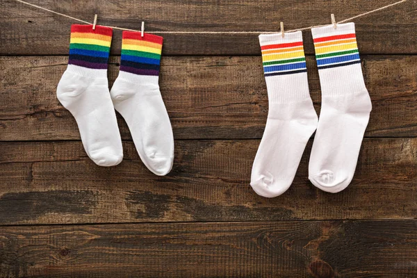 Zwei Paar Weiße Socken Mit Regenbogenstreifen Auf Holzgrund Wäscheklammern Aufgehängt — Stockfoto