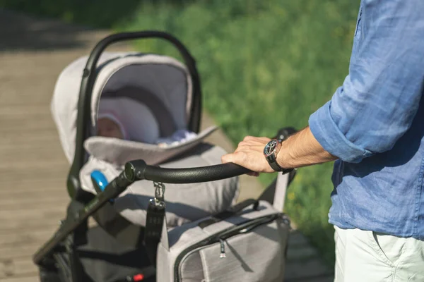 Nahaufnahme Männerhände Mit Kinderwagen Junger Papa Der Mit Baby Kinderwagen lizenzfreie Stockfotos