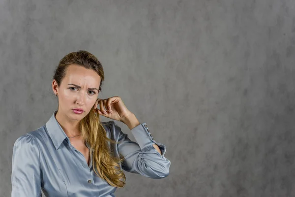 Gri bir arka plan üzerinde güzel kız yakından görünüyor ve elini var