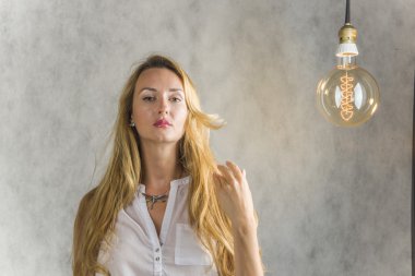 Güzel kız gri bir arka plan ve vintage bir elektrik lambaları