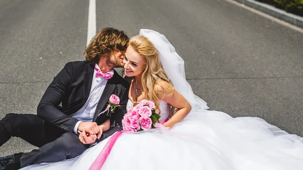 Bruidspaar zittend op de grond — Stockfoto