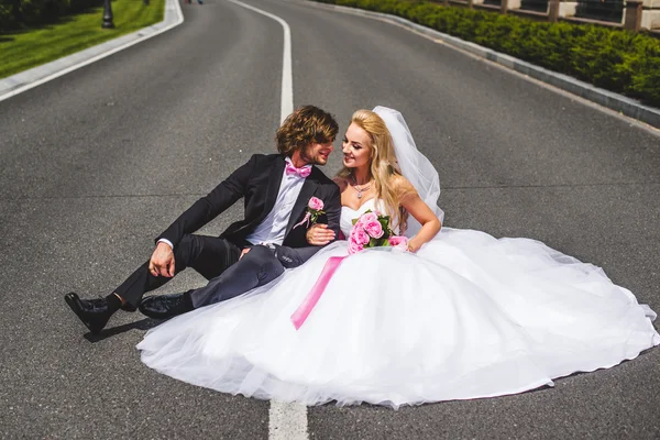 Wedding couple sitting on ground — Stock Photo, Image