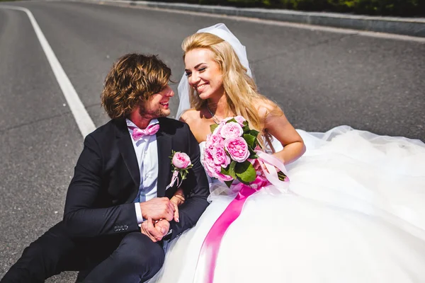 Wedding couple sitting on ground — Stock Photo, Image