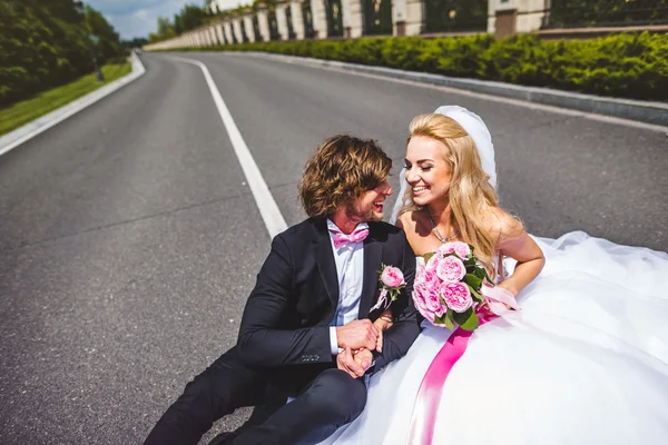 Wedding couple sitting on ground — Stock Photo, Image