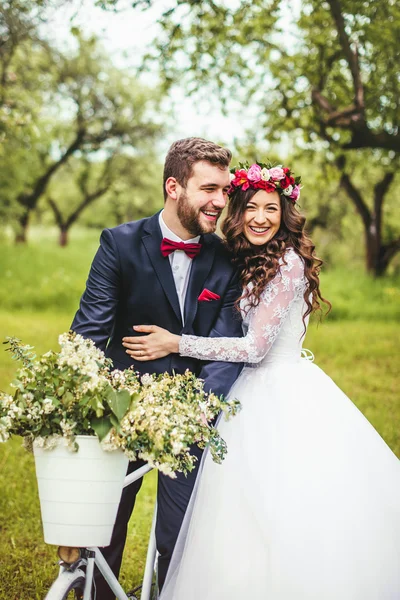 Sposa e sposo in posa vicino alla bicicletta — Foto Stock