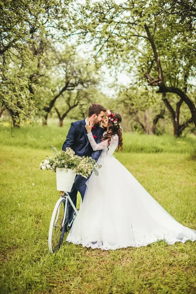 Sposa e sposo in posa vicino alla bicicletta — Foto Stock