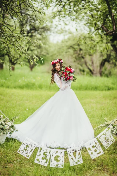 Noiva em vestido branco em um jardim — Fotografia de Stock