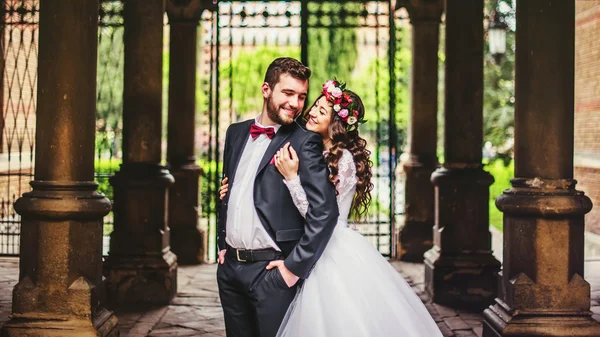 Groom and bride near the columns — Stock Photo, Image