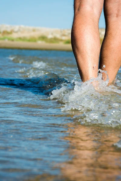 bir güneşli gün sahil üzerinde yürüyen adam