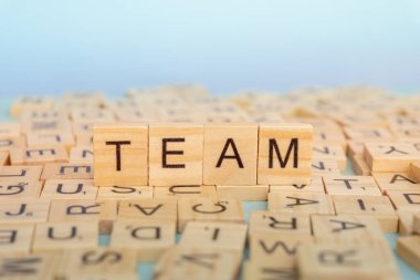 Tahta bloklar düz bir yüzey üzerinde kelime takımı anlamına gelir. Çevredeki harfler eğlenceli bir sahne yaratıyor. Resim işbirliği ve grup çalışmasını temsil ediyor